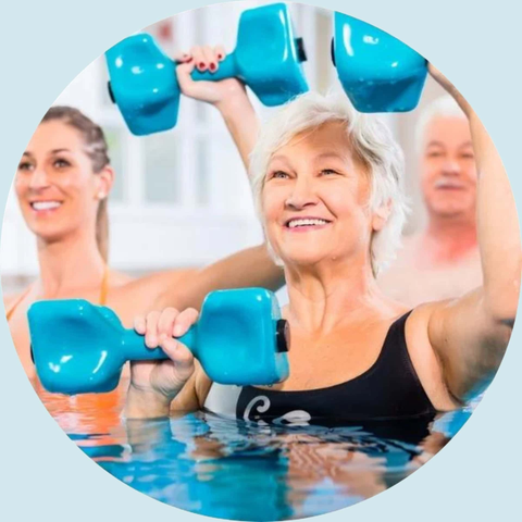 Ældre dame i vand som laver hold gymnastik med vandvægte.